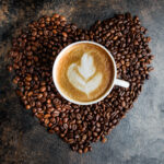 top view cappuccino on a background of coffee beans in the form of a heart